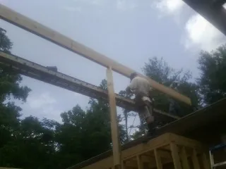Carpenter setting a ridge beam over a new addition frame — Ice Dam Removal by Roofing Brothers in Bazine