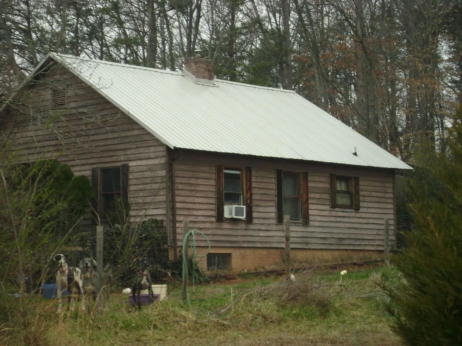 White metal roof on an old wood sided farmhouse, from a Metal Roof Installation job in Bazine